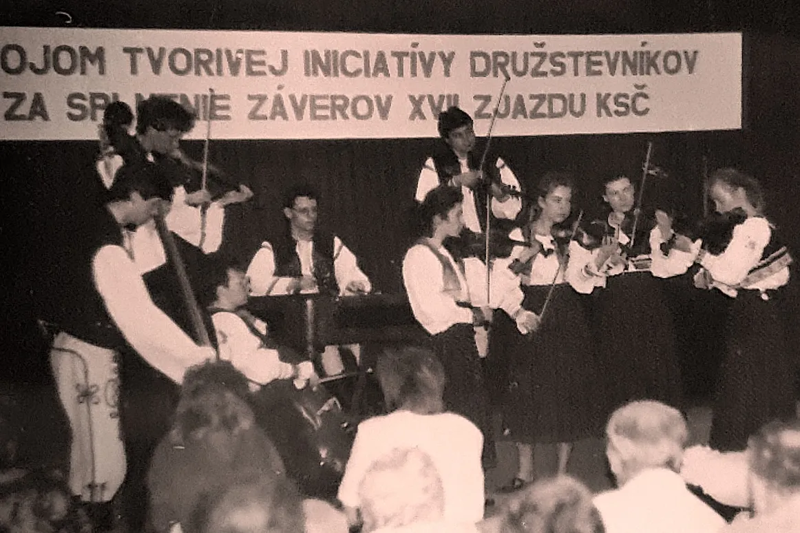 Milan Vodrážka playing cimbalom with a folklore ensemble on stage